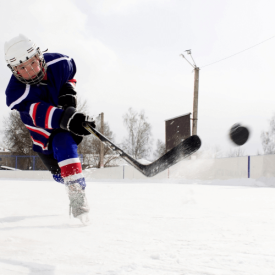 Young hockey player shooting puck at outdoor rink VI Storm Athletics