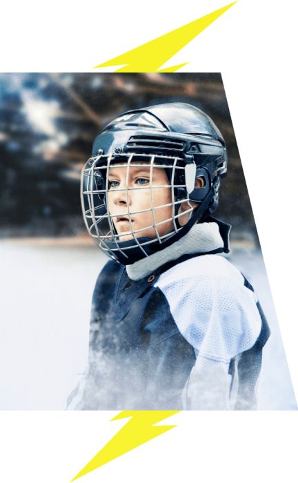 A young boy looks off screen. He is wearing his hockey gear.