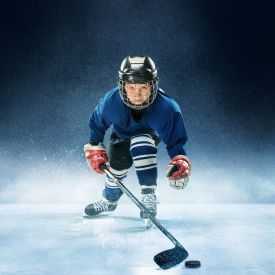 Kids hockey player posing for the camera on the ice