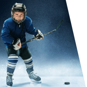 A young boy hockey player poses for a photo with a puck.
