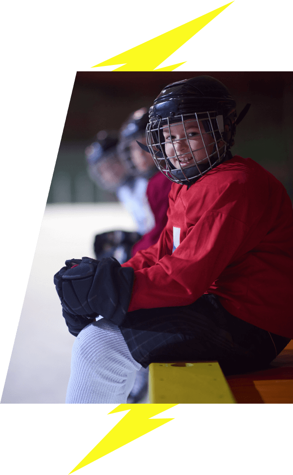 Kids hockey player sitting on the bench smiling VI Storm Athletics